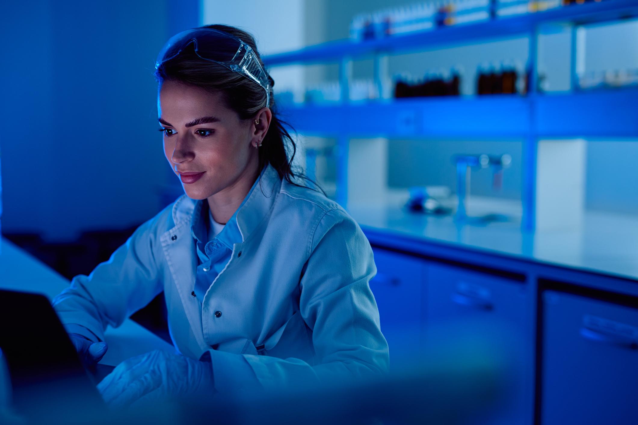 Female longevity scientist analyzing NAD+ cellular research in laboratory